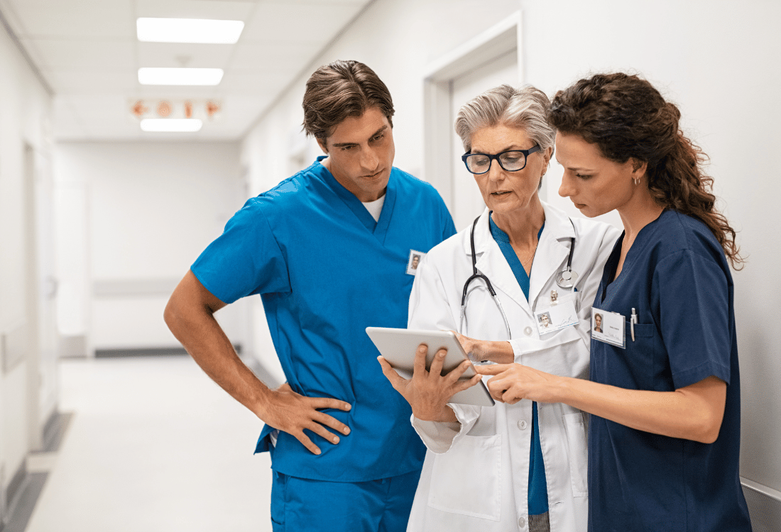 A group of medical staff discussing the advantages of using file tracking software to enhance their NHS trust operations.